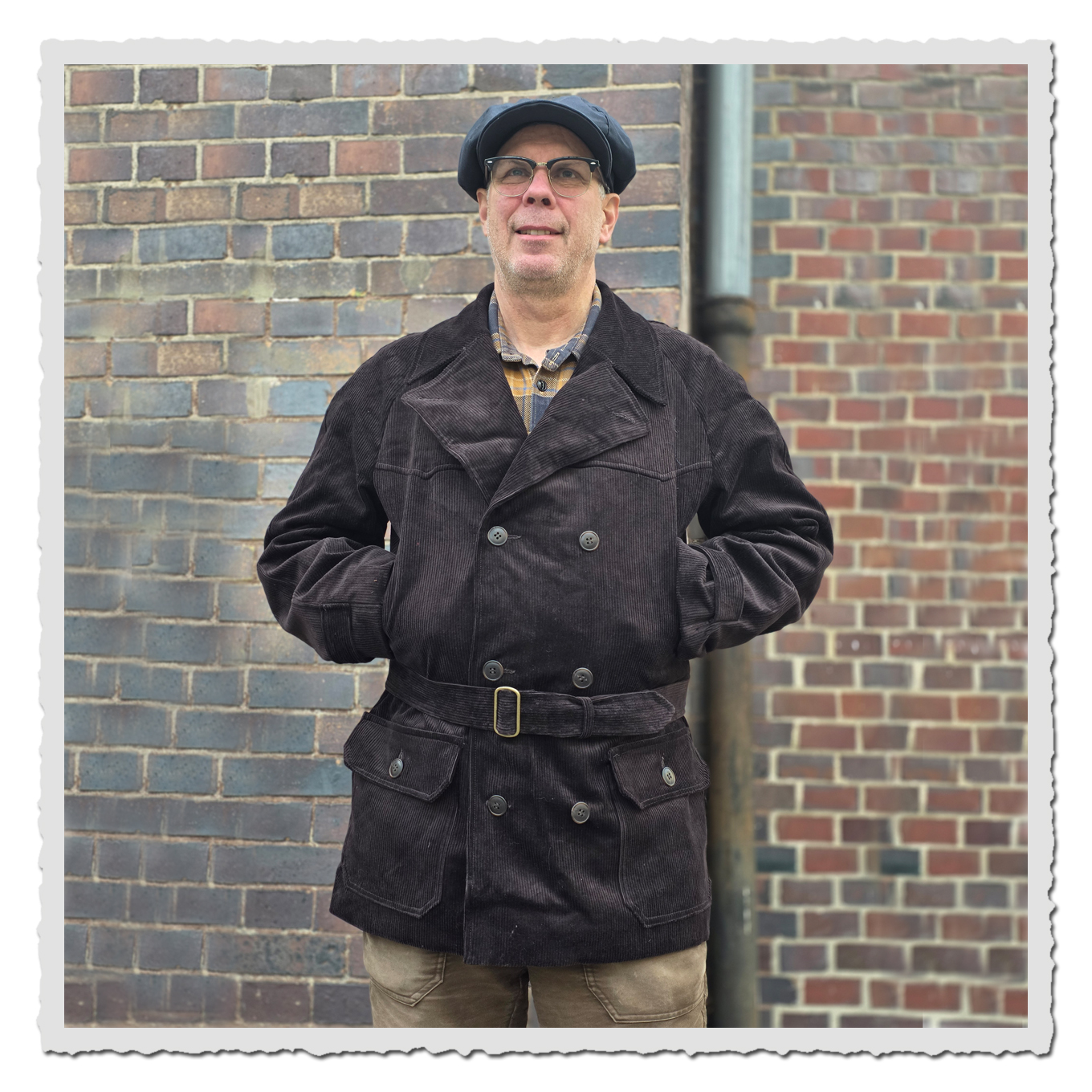 Kutscherjacke Fritz schwarzbraun im getragenen Look vor Backsteinwand